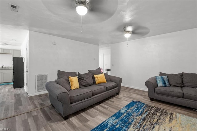 living room featuring ceiling fan and wood-type flooring