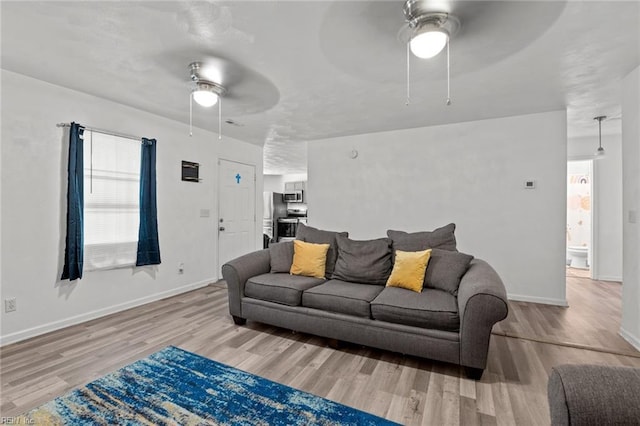 living room featuring ceiling fan and light hardwood / wood-style flooring