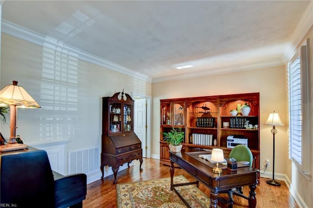 home office with ornamental molding and light hardwood / wood-style flooring