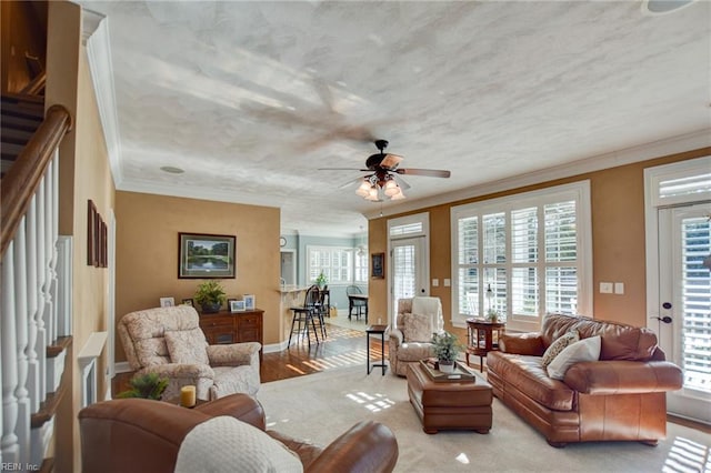 living room with ceiling fan, light wood-type flooring, and ornamental molding