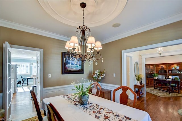 dining room featuring ornamental molding, an inviting chandelier, and hardwood / wood-style flooring