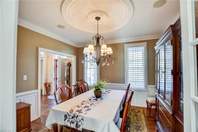 dining space with dark hardwood / wood-style flooring, crown molding, and a chandelier