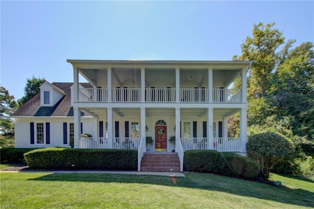 view of front of house with a front yard, a porch, and a balcony