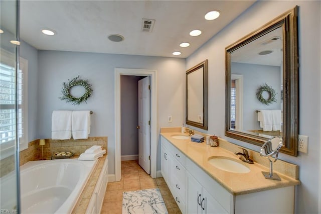 bathroom with vanity, tile patterned floors, and tiled bath