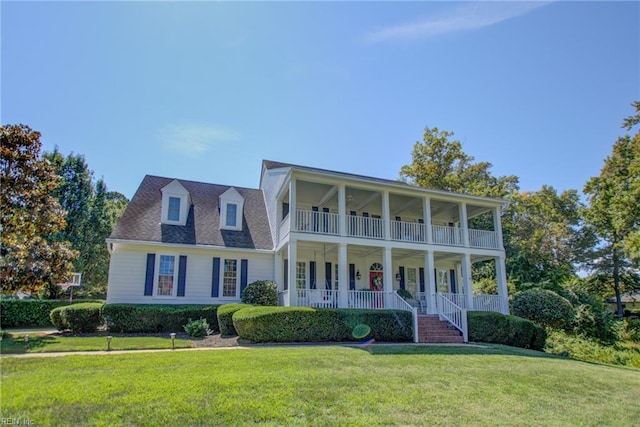 view of front of house with a balcony, a porch, and a front lawn