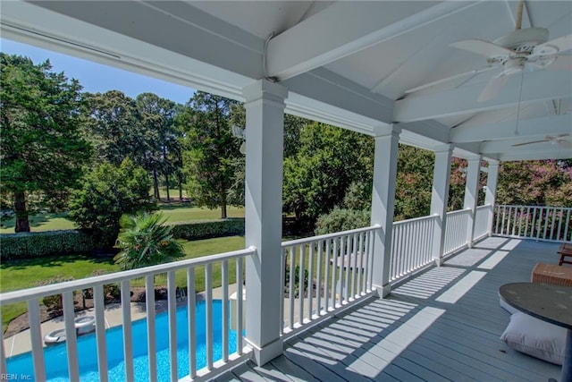 wooden terrace with ceiling fan and a yard