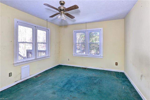 carpeted spare room featuring ceiling fan