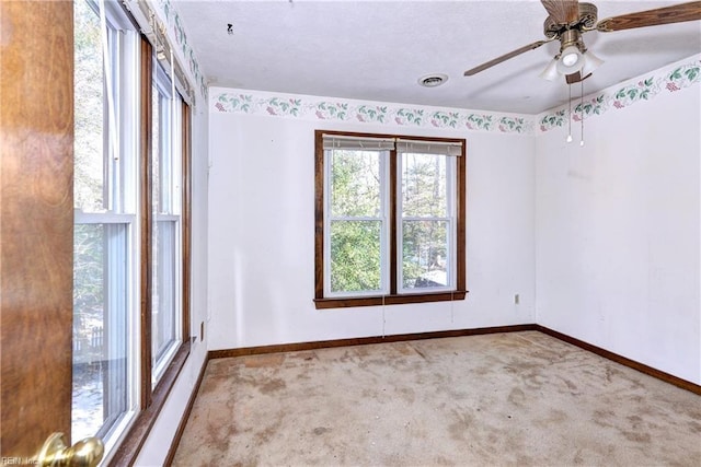 carpeted spare room featuring ceiling fan