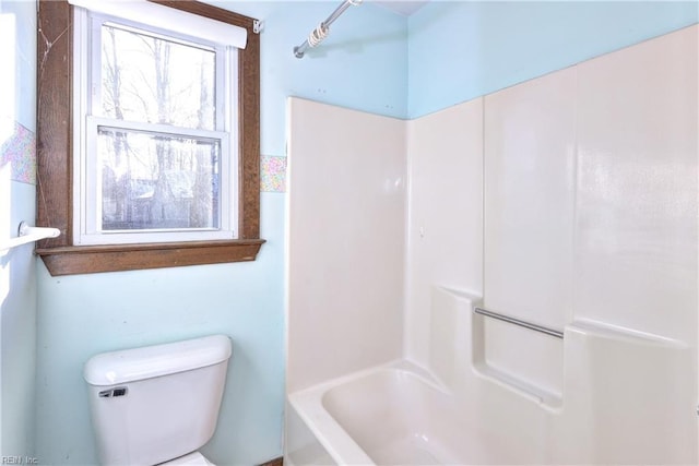 bathroom with bathtub / shower combination and toilet