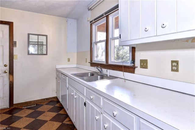 kitchen with sink, white cabinetry, and dishwasher