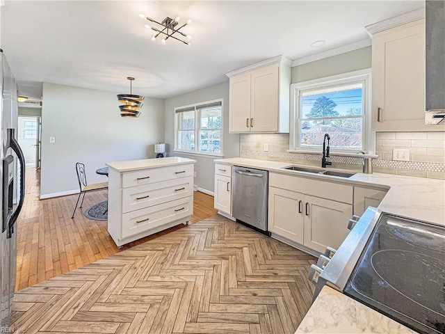 kitchen with sink, decorative backsplash, appliances with stainless steel finishes, decorative light fixtures, and white cabinetry