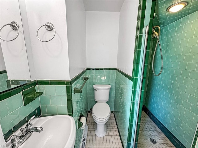 bathroom featuring tile patterned floors, sink, toilet, tile walls, and walk in shower