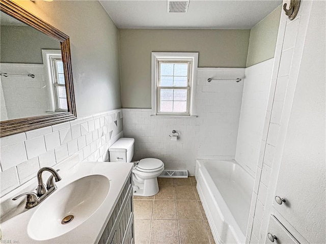 bathroom with tile patterned floors, vanity, tile walls, and toilet