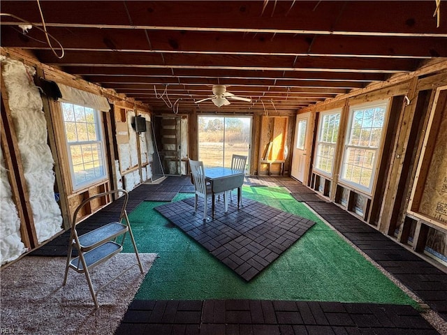 unfurnished sunroom with ceiling fan