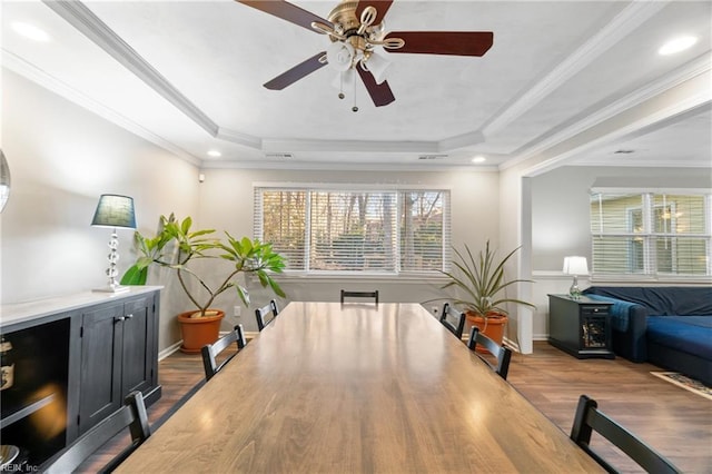 dining room with ornamental molding, a tray ceiling, and hardwood / wood-style flooring