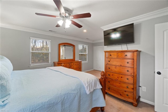 bedroom featuring a closet, ceiling fan, crown molding, and light carpet