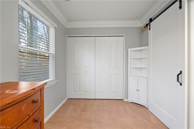 bedroom with ornamental molding, a closet, light carpet, and a barn door