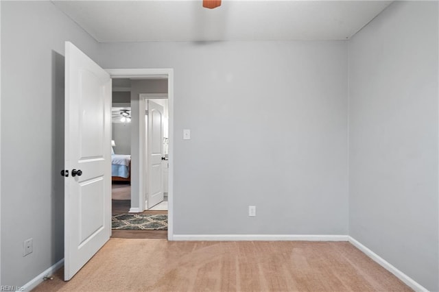 spare room with light colored carpet and ceiling fan