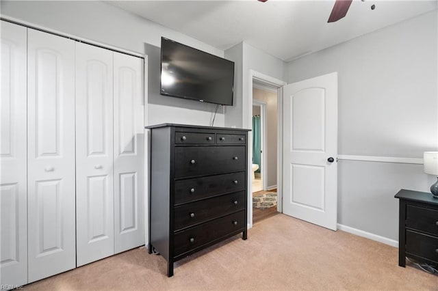 bedroom featuring ceiling fan, a closet, and light carpet