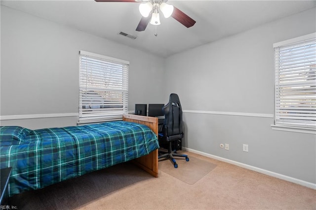 bedroom with ceiling fan, multiple windows, and carpet