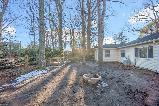 view of yard with an outdoor fire pit and central air condition unit