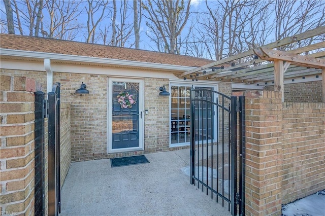 entrance to property featuring a pergola and a patio