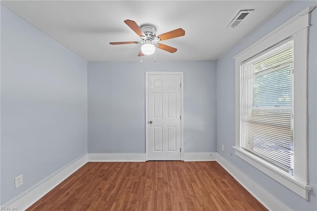 empty room with hardwood / wood-style floors and ceiling fan