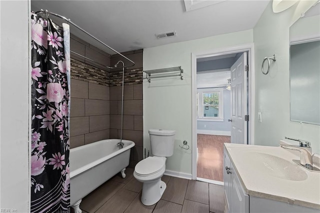 full bathroom with vanity, shower / tub combo, and toilet