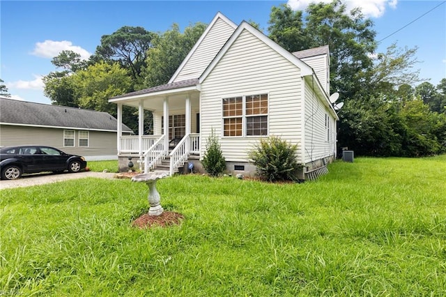 view of front of home featuring a porch, a front yard, and central AC