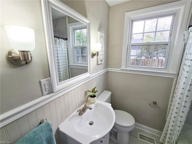 bathroom featuring toilet, tile patterned floors, sink, and a shower with shower curtain