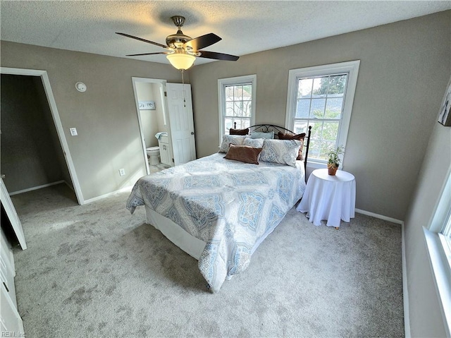 bedroom featuring connected bathroom, ceiling fan, a textured ceiling, and light colored carpet