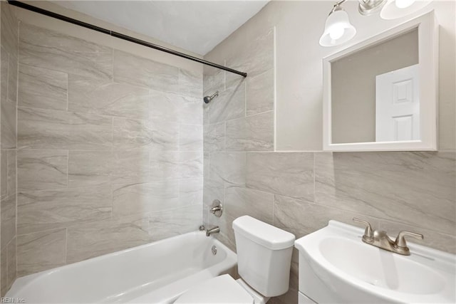 full bathroom with vanity, tiled shower / bath, tile walls, and toilet