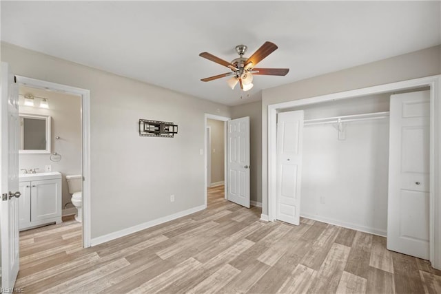 unfurnished bedroom featuring ceiling fan, a closet, ensuite bathroom, and light wood-type flooring