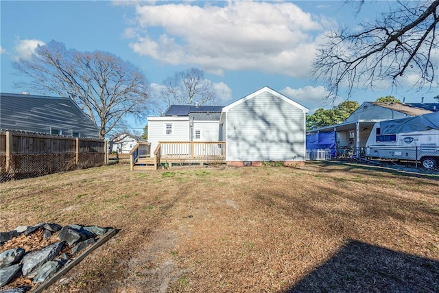 rear view of property with a yard and a wooden deck