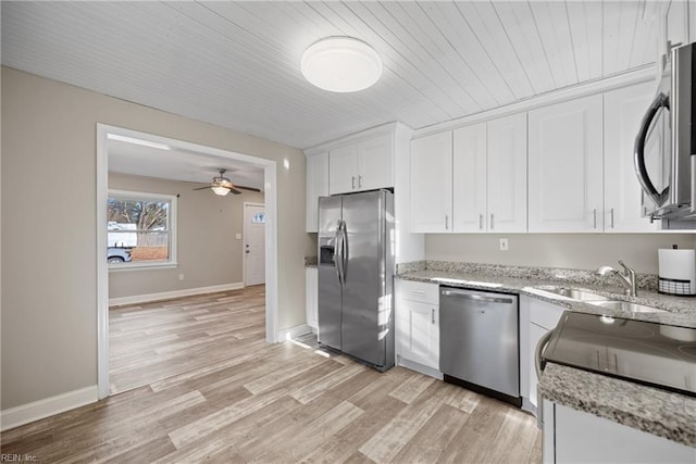 kitchen featuring light stone counters, stainless steel appliances, sink, light hardwood / wood-style flooring, and white cabinets