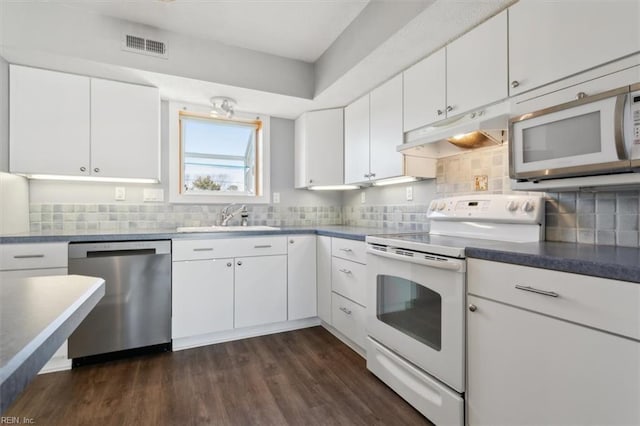 kitchen with sink, white appliances, white cabinetry, and tasteful backsplash