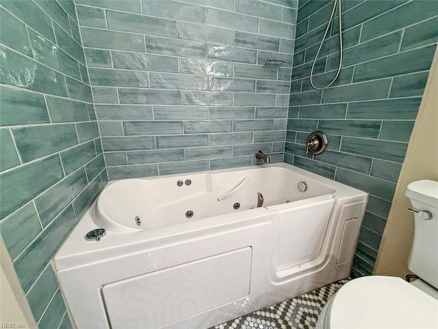 bathroom with toilet, a washtub, and tile patterned floors