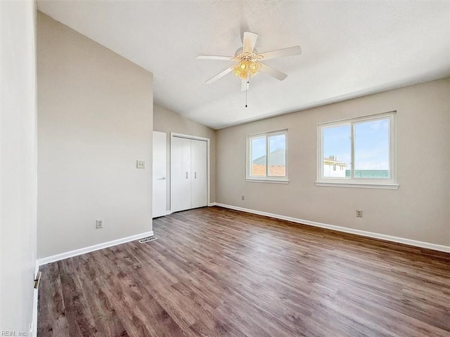 empty room featuring lofted ceiling, hardwood / wood-style floors, and ceiling fan