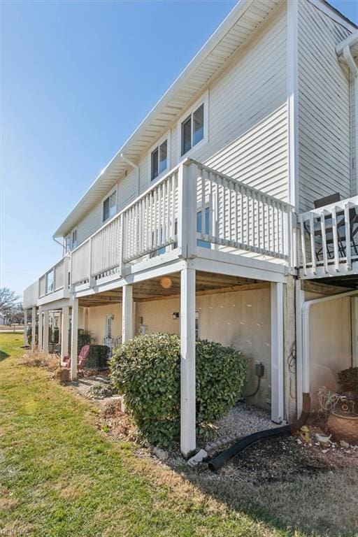 rear view of property with a lawn and a wooden deck