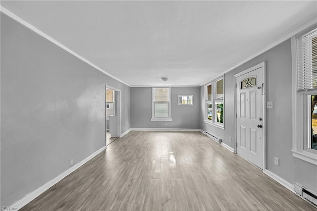 foyer with wood-type flooring, crown molding, and a baseboard radiator