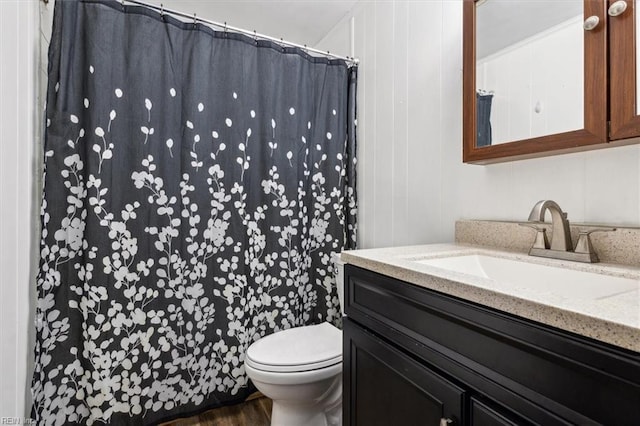 bathroom with wood-type flooring, vanity, and toilet