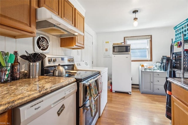 kitchen featuring dark stone counters, stainless steel appliances, and light hardwood / wood-style floors