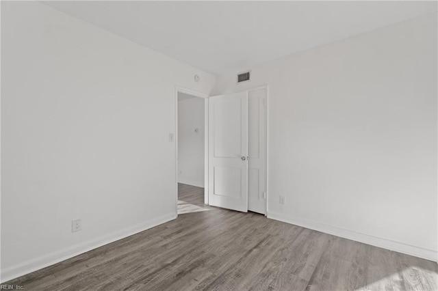 unfurnished room with wood-type flooring