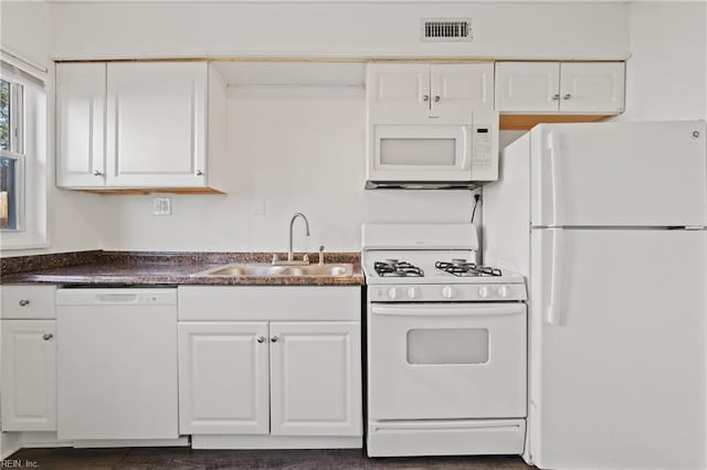 kitchen with white appliances, white cabinets, and sink