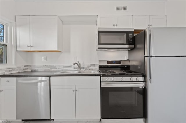 kitchen featuring stainless steel appliances, white cabinetry, and sink