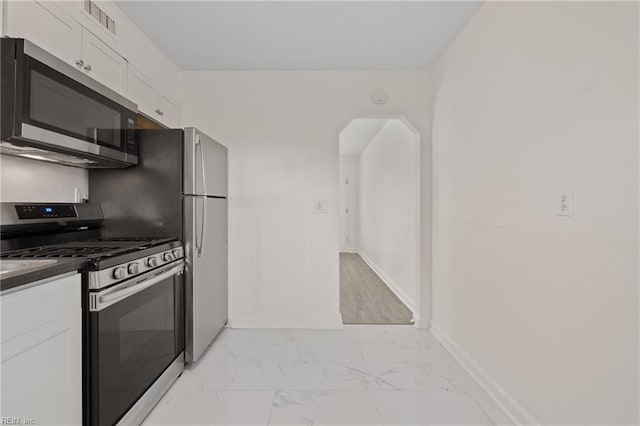 kitchen featuring stainless steel appliances and white cabinetry