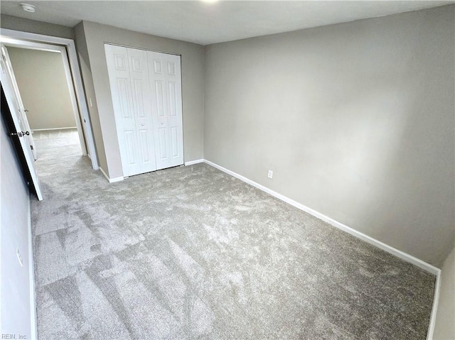 unfurnished bedroom featuring light colored carpet and a closet