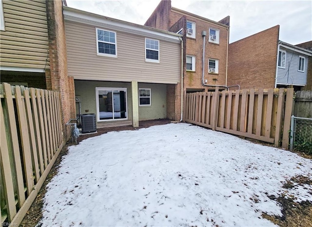 snow covered house featuring central AC unit