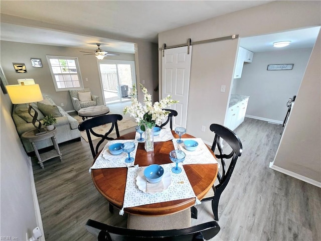 dining room with hardwood / wood-style floors, ceiling fan, and a barn door