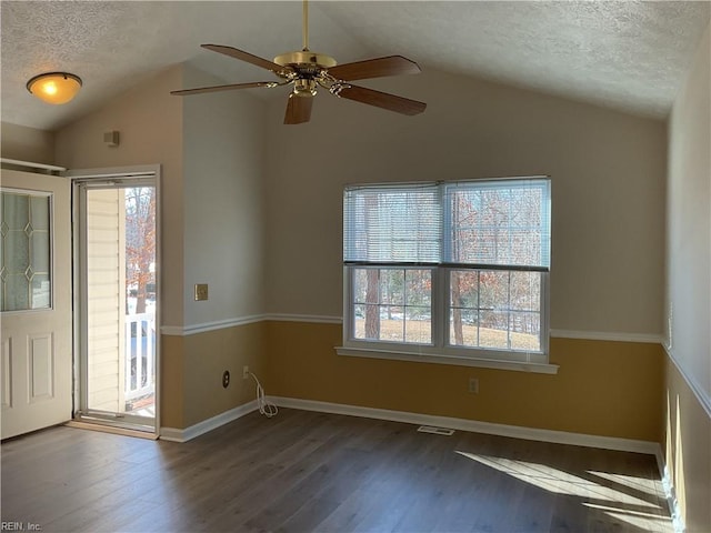 unfurnished room featuring dark hardwood / wood-style flooring, a wealth of natural light, and vaulted ceiling